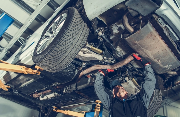 mechanik naprawiający auto